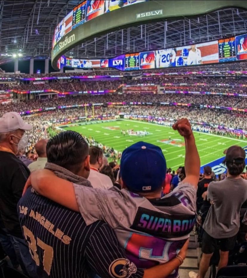 Cheering dad and son attending Super Bowl LVII at State Farm Stadium